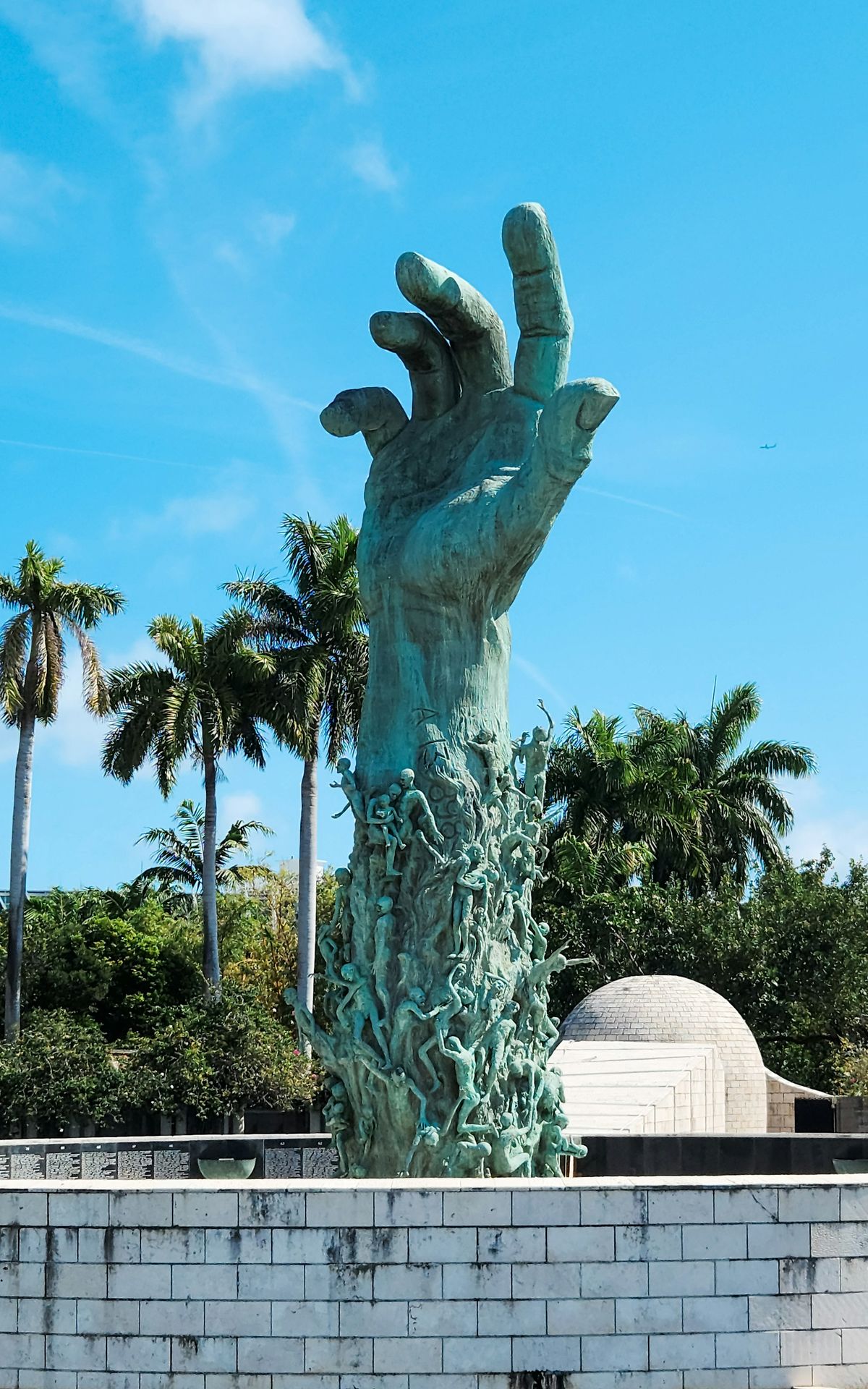 A statue of a hand reaching up into the sky